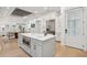 Modern kitchen with an island featuring seating, built-in microwave, and refrigerator, seamlessly connecting to dining area at 6 Beverly Rd, Charleston, SC 29407