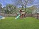 Backyard with a wooden playset, slide, green lawn, and fenced perimeter for privacy and play at 8530 Bentwood Dr, North Charleston, SC 29406