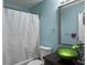 Bathroom with a glass bowl sink, mirror, white shower curtain, and toilet against an aqua-painted wall at 8530 Bentwood Dr, North Charleston, SC 29406