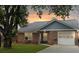 Charming brick home with an attached garage, complemented by a lush green lawn and mature trees at 8530 Bentwood Dr, North Charleston, SC 29406