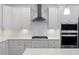 Bright kitchen showcasing white cabinetry, a modern range hood, and stainless steel appliances at 861 Recess Point Dr, Moncks Corner, SC 29461