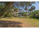 Picturesque two-story home with a screened porch, surrounded by lush greenery and palm trees in a serene setting at 864 Club Cottage Rd, Edisto Beach, SC 29438