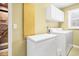Laundry room with front-load washer/dryer and upper cabinets, providing convenience and storage at 864 Club Cottage Rd, Edisto Beach, SC 29438