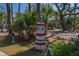 Whimsical lighthouse lawn ornament surrounded by vibrant greenery adds charm to the property's exterior at 864 Club Cottage Rd, Edisto Beach, SC 29438
