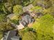 Aerial view of a brick home with a patio and backyard nestled among lush greenery, showcasing its spacious lot at 8795 E Fairway Woods Cir, North Charleston, SC 29420