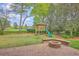 Landscaped backyard with patio, built-in brick fire pit, and a ' playhouse at 8795 E Fairway Woods Cir, North Charleston, SC 29420