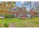Brick two-story home with backyard patio and fire pit, overlooking manicured lawn at 8795 E Fairway Woods Cir, North Charleston, SC 29420