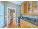 Wet bar featuring granite countertops, wood cabinets, and a beverage refrigerator at 8795 E Fairway Woods Cir, North Charleston, SC 29420