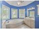 Bright bathroom with a large tub, marble floors, and plenty of natural light at 8795 E Fairway Woods Cir, North Charleston, SC 29420