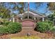 Beautifully landscaped entrance to the Coosaw Creek Clubhouse with brick accents and mature shrubs at 8795 E Fairway Woods Cir, North Charleston, SC 29420