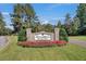 Coosaw Creek Country Club entrance sign with blooming flowers, showcasing a welcoming and picturesque community at 8795 E Fairway Woods Cir, North Charleston, SC 29420
