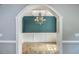 Open archway showcasing the dining room with hardwood floors, wainscoting, and a decorative chandelier at 8795 E Fairway Woods Cir, North Charleston, SC 29420