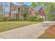 Charming two-story brick home with a long driveway, attached garage, and mature landscaping at 8795 E Fairway Woods Cir, North Charleston, SC 29420