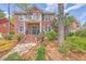 Beautiful two-story brick house with a covered porch, balcony, manicured landscaping, and charming details at 8795 E Fairway Woods Cir, North Charleston, SC 29420