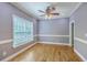 Cozy living area with hardwood floors, large window, ceiling fan, and neutral-toned walls at 8795 E Fairway Woods Cir, North Charleston, SC 29420