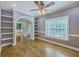Comfortable living area featuring hardwood floors, a ceiling fan, built-in shelves, and a large window at 8795 E Fairway Woods Cir, North Charleston, SC 29420