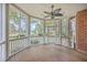 Spacious screened porch with wood floors and ceiling fan overlooks large, landscaped yard at 8795 E Fairway Woods Cir, North Charleston, SC 29420
