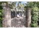 Private backyard oasis with brick patio, iron gate, lounge chairs and lush landscaping at 106 Beaufain St, Charleston, SC 29401