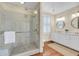 Luxurious bathroom with marble shower, double vanity, and decorative gold wallpaper at 106 Beaufain St, Charleston, SC 29401