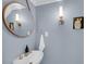 Charming powder room featuring a modern sink, gold fixtures, and a round decorative mirror at 106 Beaufain St, Charleston, SC 29401