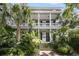 Charming two-story home with a double porch, American flag, lush landscaping and brick steps at 106 Beaufain St, Charleston, SC 29401