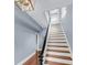 Elegant staircase with white risers and wooden treads, complemented by a dark wooden banister at 106 Beaufain St, Charleston, SC 29401