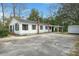 Charming exterior featuring white siding, black shutters, brick chimney, and ample parking space at 109 Gerideau St, Walterboro, SC 29488