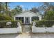 Inviting front exterior with white siding, lion statues, a screened in porch, and neat landscaping at 109 Gerideau St, Walterboro, SC 29488