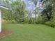 Lush green backyard featuring a grassy lawn surrounded by mature trees and landscaping at 1133 Mount Batten Dr, Hanahan, SC 29410