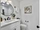 Modern bathroom with a vanity, round mirror, and glass shower door in a neutral color palette at 1133 Mount Batten Dr, Hanahan, SC 29410