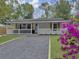 Charming one story home featuring a quaint front porch and rock driveway enhanced by the vibrant color of the azalea bush at 1133 Mount Batten Dr, Hanahan, SC 29410