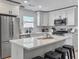 Bright kitchen features stainless steel appliances, white cabinetry, and a large island with black barstools at 1133 Mount Batten Dr, Hanahan, SC 29410