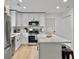 Modern kitchen features stainless steel appliances, white cabinetry, and a sleek island with black stools at 1133 Mount Batten Dr, Hanahan, SC 29410