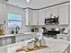Bright kitchen features stainless steel appliances, white cabinetry, and a kitchen island with quartz countertops at 1133 Mount Batten Dr, Hanahan, SC 29410
