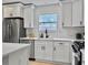 Close-up of a bright kitchen with white cabinets, quartz countertops, and a modern black faucet at 1133 Mount Batten Dr, Hanahan, SC 29410