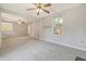 Large, airy living room with neutral paint, plush carpeting, and view into the kitchen at 115 Foxborough Rd, Goose Creek, SC 29445