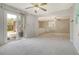 Spacious living room with ceiling fan, sliding door, and view into kitchen area at 115 Foxborough Rd, Goose Creek, SC 29445