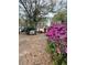 Charming home featuring a red door, surrounded by lush greenery and vibrant pink azaleas at 1291 Old Colony Rd, Mount Pleasant, SC 29464
