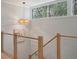 Stylish staircase with wooden railings and a modern light fixture above at 1330 Sea Elder Dr # E, Kiawah Island, SC 29455