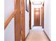 Hallway with neutral carpet and a wooden banister, door, and trim at 1438 Arrow Wind Ter, Charleston, SC 29414