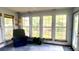 Bright sunroom with many windows, a comfortable chair, and a lush plant creates a relaxing space at 1438 Arrow Wind Ter, Charleston, SC 29414