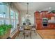 Bright dining area with wood table and chairs adjacent to the kitchen, featuring natural light at 145 Billowing Sails St, Summerville, SC 29486