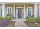 Inviting front porch featuring rocking chairs, elegant columns, and a beautifully decorated front door at 145 Billowing Sails St, Summerville, SC 29486