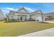 Well-maintained single-story home with lush landscaping, an inviting covered porch, and an attached garage at 145 Billowing Sails St, Summerville, SC 29486