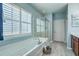 Main bathroom featuring a separate shower and tub, and large window with plantation shutters at 145 Billowing Sails St, Summerville, SC 29486