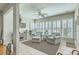 Bright sun room with two sitting chairs, an ottoman, plantation shutters, and tiled floors at 145 Billowing Sails St, Summerville, SC 29486