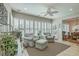 Bright sun room with two sitting chairs, an ottoman, plantation shutters, and tiled floors at 145 Billowing Sails St, Summerville, SC 29486
