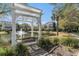 Enjoy a tranquil view of the pond from a charming pergola swing, surrounded by lush landscaping at 1501 Sea Palms Cres, Mount Pleasant, SC 29464