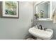 Stylish powder room with elegant pedestal sink, decorative mirror, and soft blue walls at 1501 Sea Palms Cres, Mount Pleasant, SC 29464
