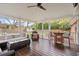 This covered back porch has string lights, a ceiling fan, wood floors, outdoor seating, and access to the back yard at 1515 Wakendaw Rd, Mount Pleasant, SC 29464